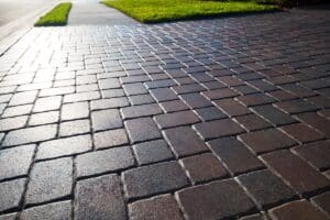 Close up showing driveway sealant to protect the bricks. Sealcoating background for new home construction.